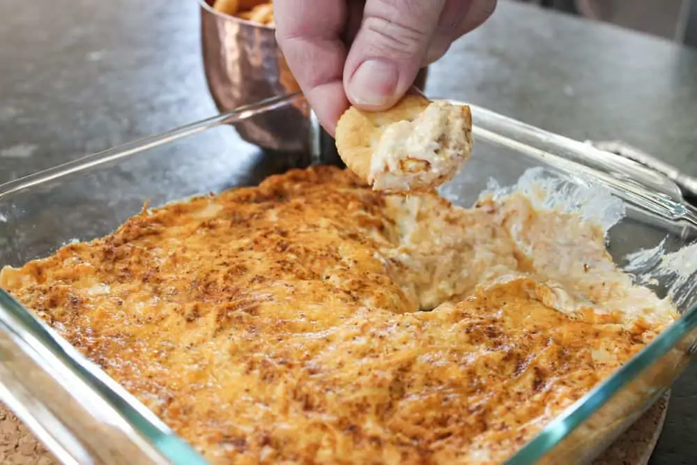 Husband dipping into the hot crab dip