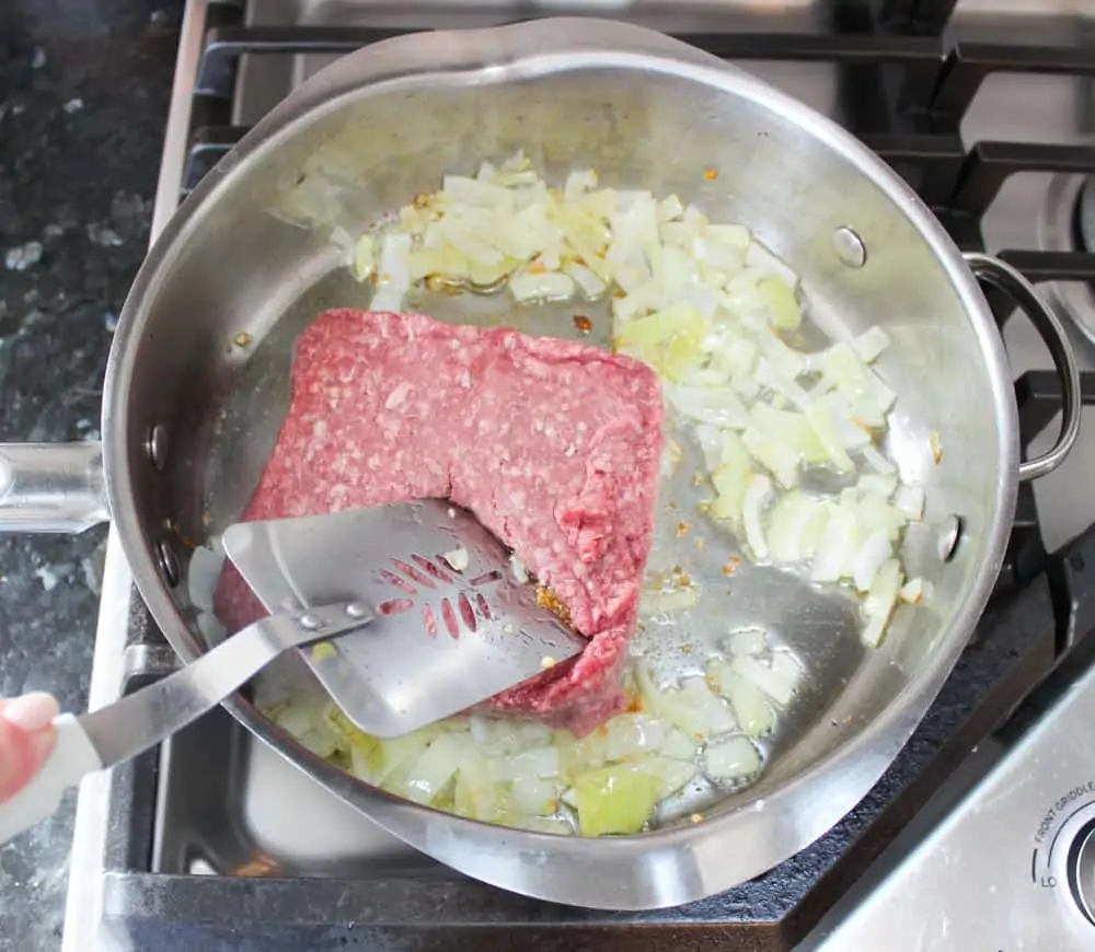 Add ground beef to cooked onions