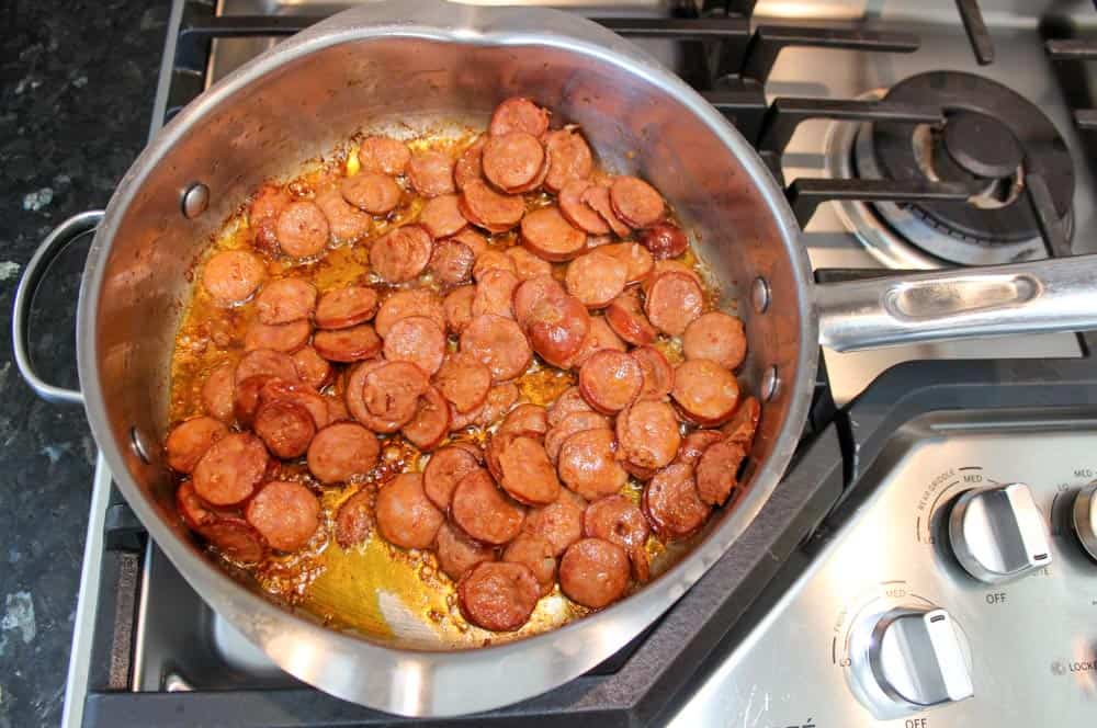 Cook andouille sausage in a skillet