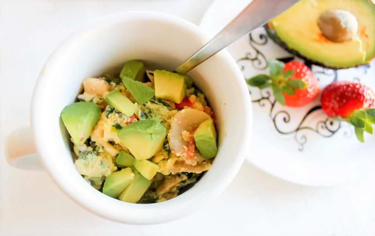 Scramble eggs in a mug with avocado on top