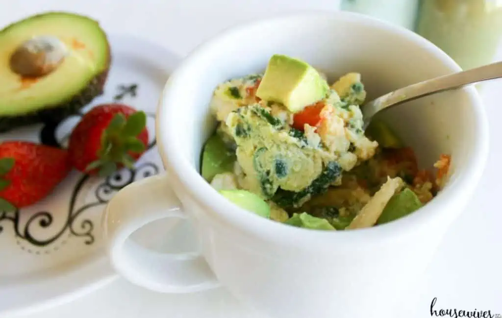 Eggs in a mug with chopped avocado