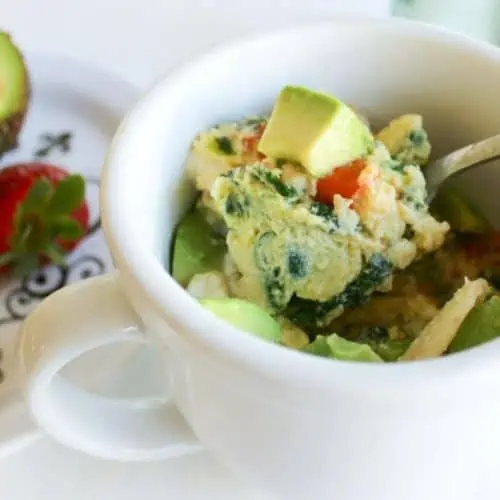 Eggs in a mug with chopped avocado