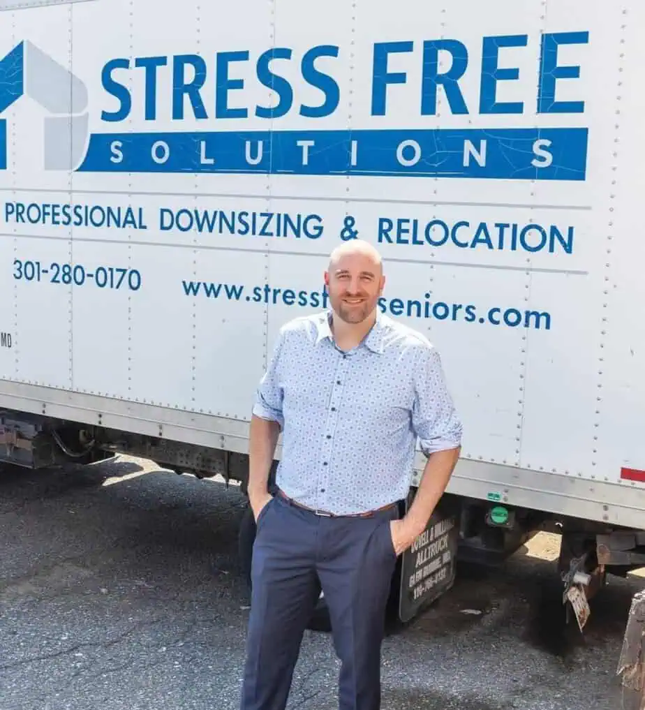 Stress Free Solutions' Owner Ryan Burns standing in front of one of his moving trucks