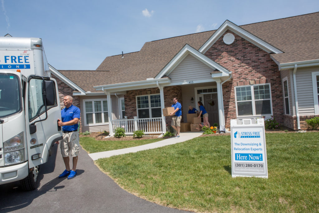 Stress Free Solutions team members moving boxes from client's home into moving truck