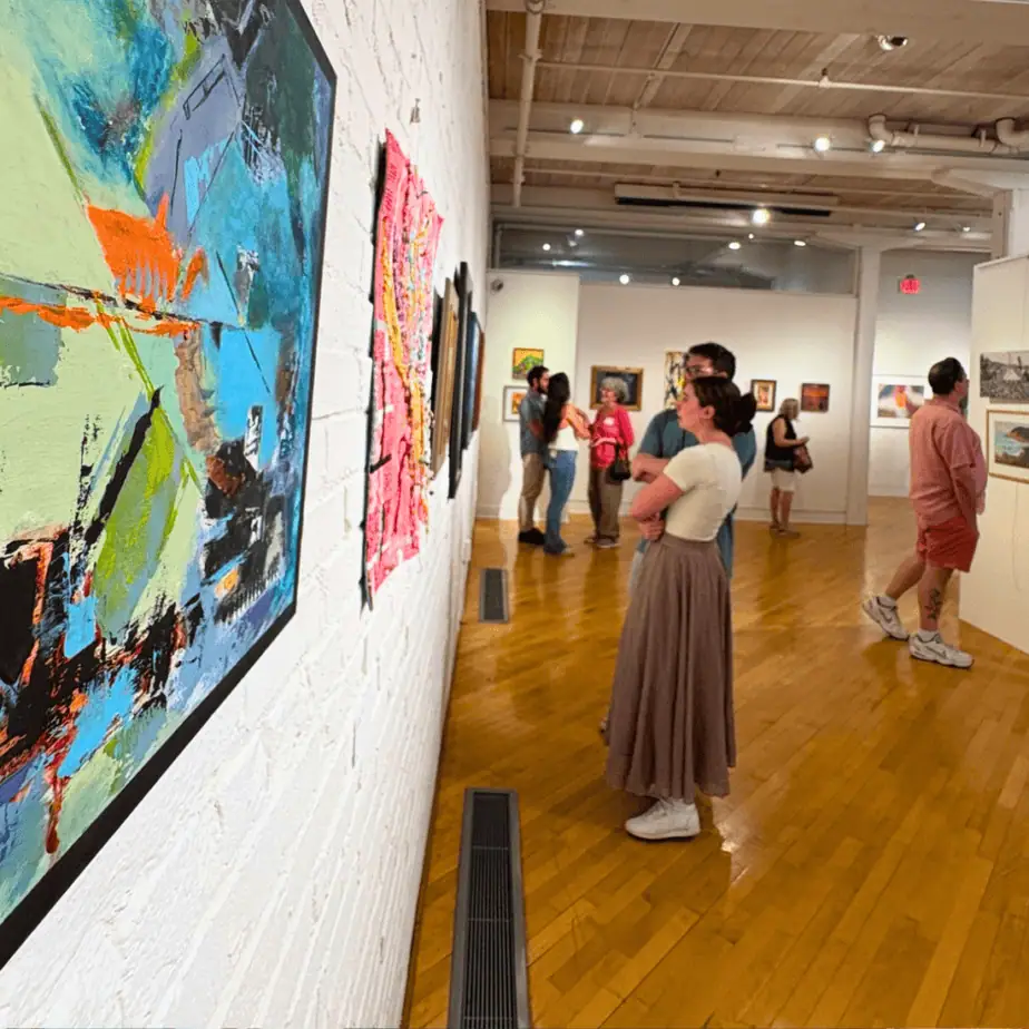 Visitors viewing artworks at an exhibition at the Delaplaine Arts Center in Downtown Frederick Maryland