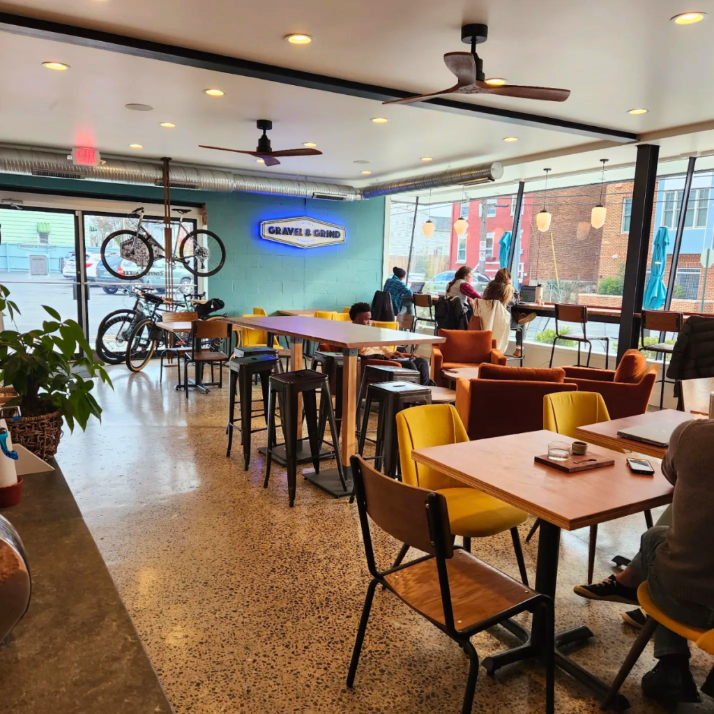 Patrons sitting at a high bar facing a huge window to Downtown Frederick at Gravel & Grind