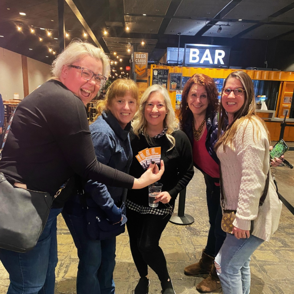 5 women holiding movie tickets standing in front of the bar at Warehouse Cinemas in Frederick MD