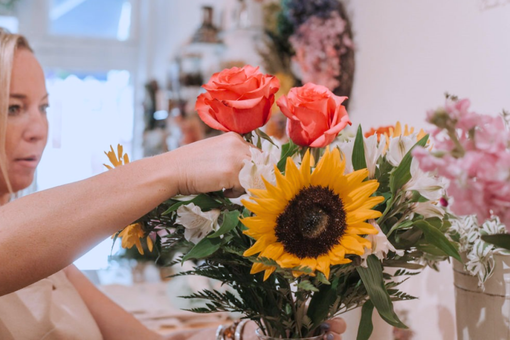 Women creating floral arrangements while enjoying Prosecco at The Frederick Floral Bar in Frederick, Maryland.