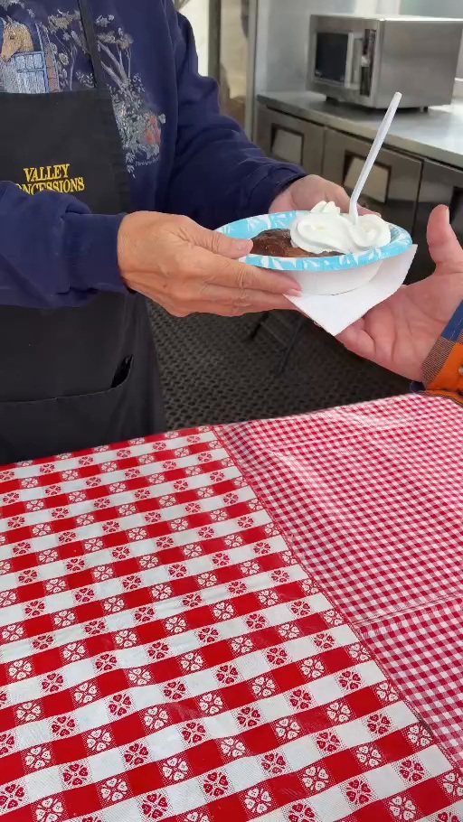 Apple dumpling with ice cream being handed to a customer at The Great Frederick Fair